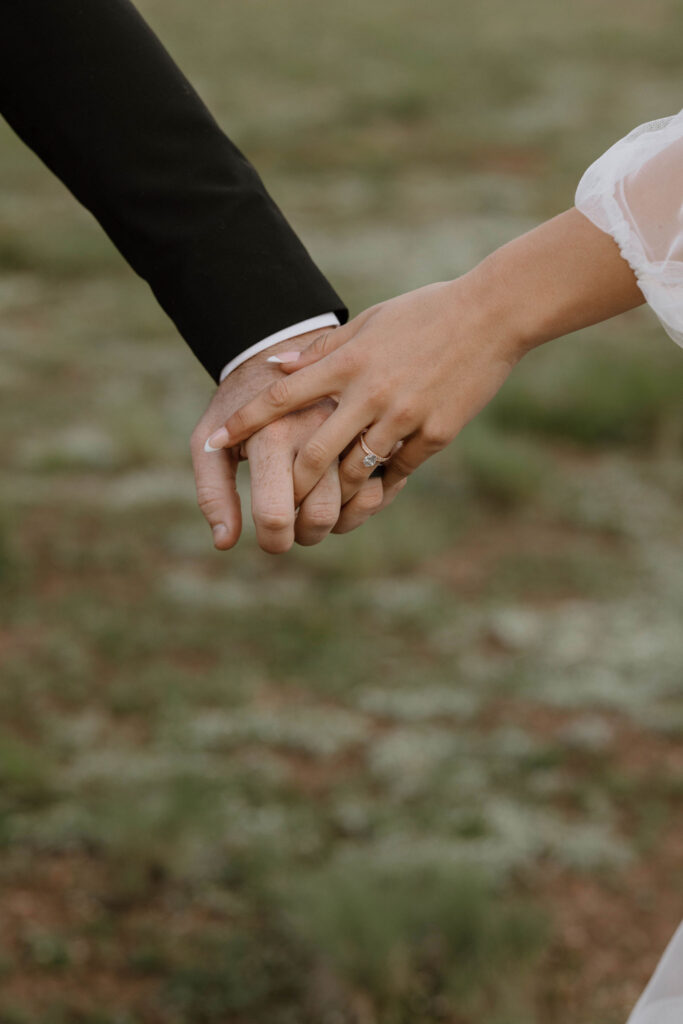 bride and groom holding hands together in the forest