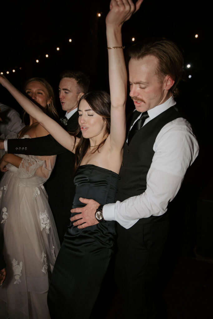 dance party photo in an outdoor forest wedding with bride and groom and family and friends