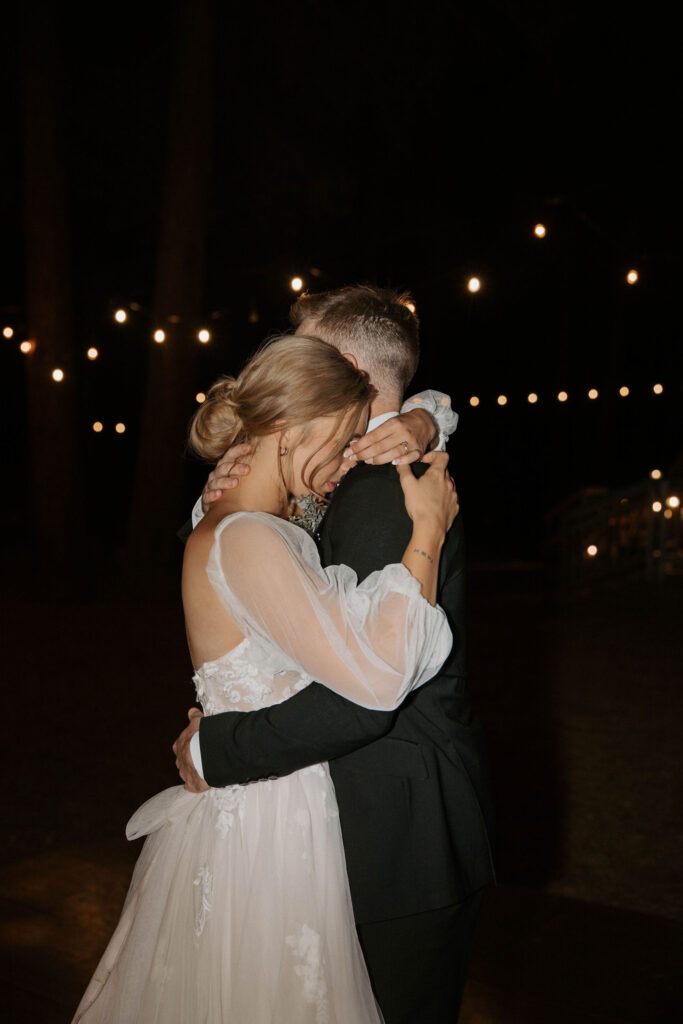 bride and groom dancing during first dance as husband and wife outdoor wedding day at arizona nordic village