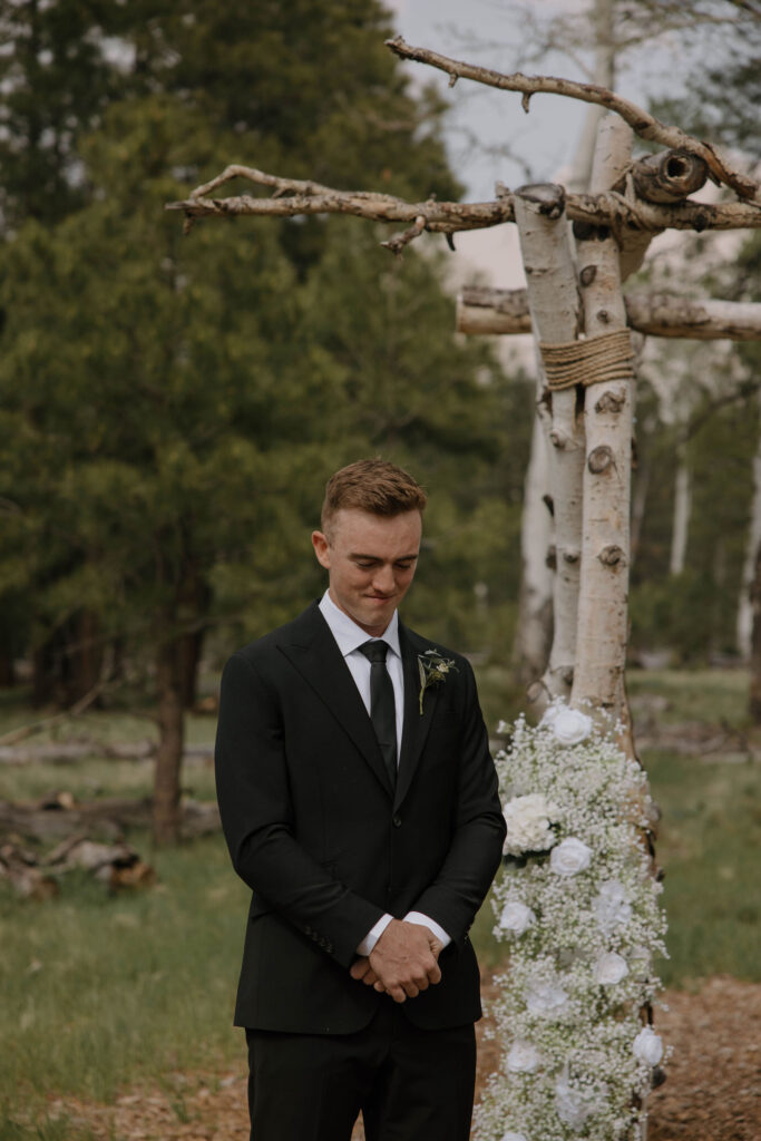 ceremony photo of groom at arbor during outdoor wedding day at arizona nordic village