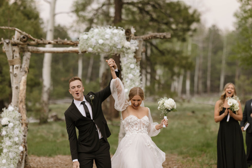 bride and groom holding hands during outdoor wedding day at arizona nordic village