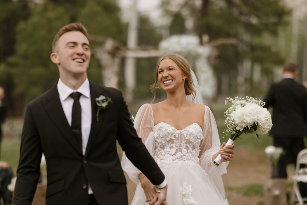 bride and groom holding hands during outdoor wedding day at arizona nordic village