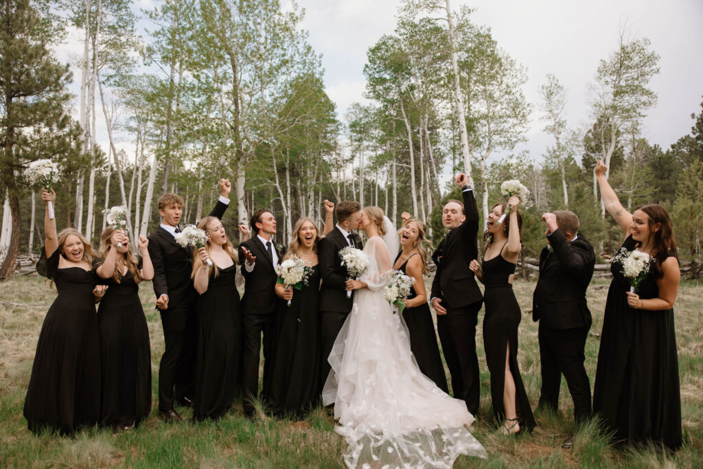 wedding party photos of bride and groom kissing with groomsmen and bridesmaids