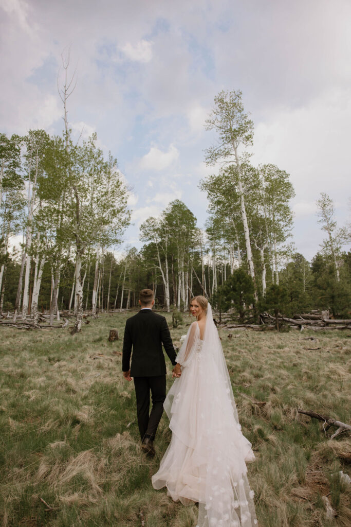 bride and groom walking together in the forest